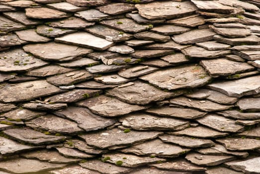 Stone tiles of slate-roof rural house as background