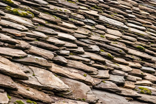 Stone tiles of slate-roof rural house as background