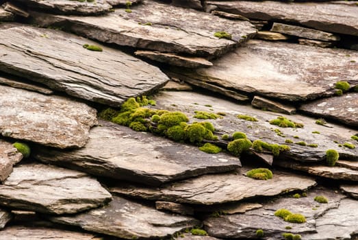 Stone tiles of slate-roof rural house as background