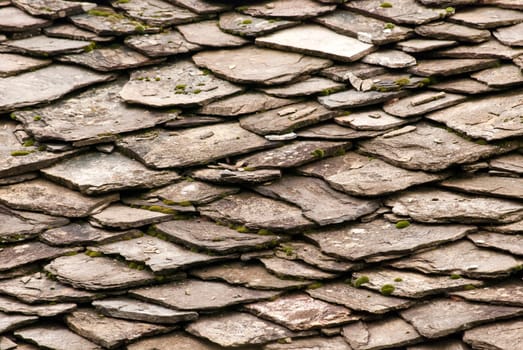 Stone tiles of slate-roof rural house as background