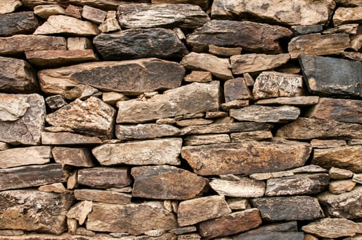 Dry masonry stone wall closeup as background