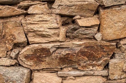 Dry masonry stone wall closeup as background