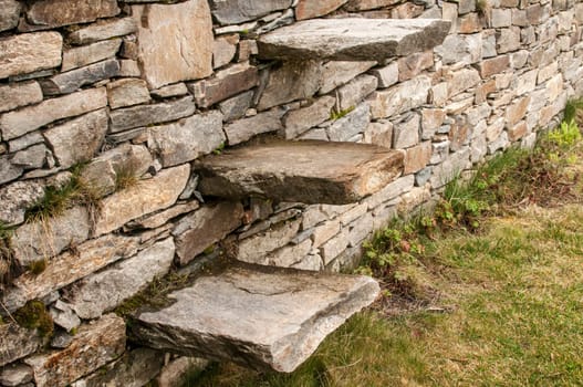 Stone steps into garden dry masonry stonewall closeup
