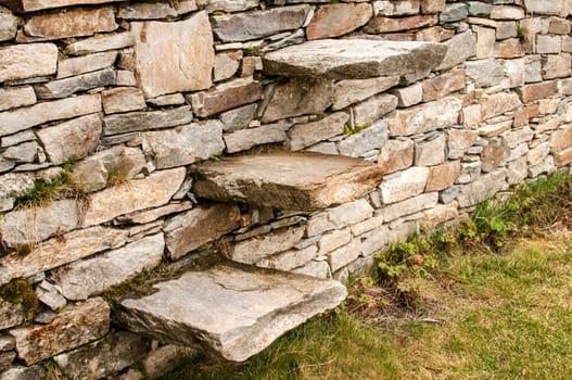 Stone steps into garden dry masonry stonewall closeup