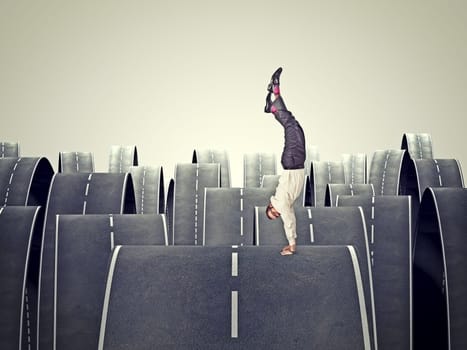 man balanced on his hands and abstract road background