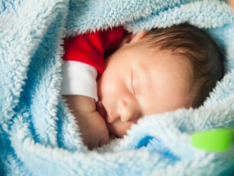 Newborn baby boy sleeping peaceful at home.