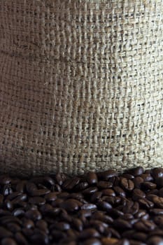 Coffee beans in a small clay pot. Image has a background of jute fibers