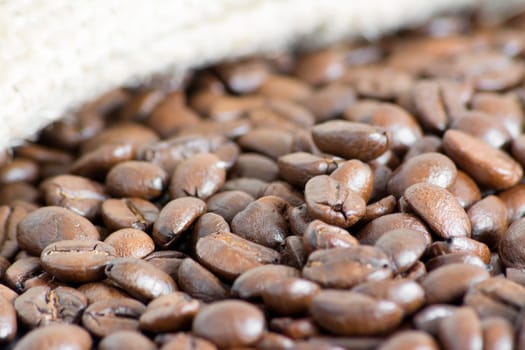 Detail of coffee beans and jute bag at background