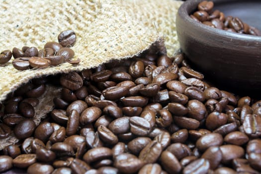 Detail of coffee beans, small clay pot and jute bag with front lighting