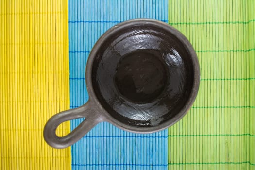 Mexican Oaxacan pottery bowl brown color on tablecloth made ​​of wooden branches.