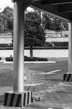 Image in black and white of a parking lot with a cart