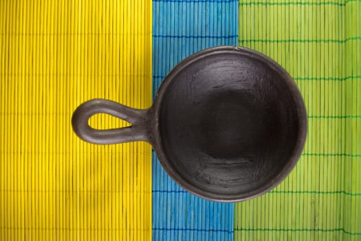 Mexican Oaxacan pottery bowl brown color on tablecloth made ​​of wooden branches.
