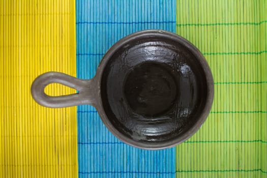 Mexican Oaxacan pottery bowl brown color on tablecloth made ​​of wooden branches.
