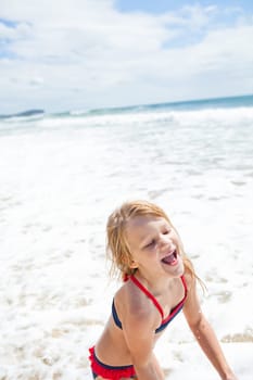 Smiling cute young girl having fun at beach on sunny day