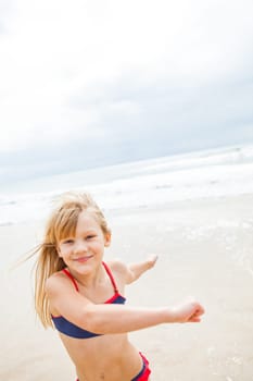 Smiling happy cute young girl having fun at beach