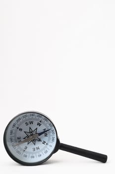Orientation Concept - Analogic Compass and Loupe on a White Background