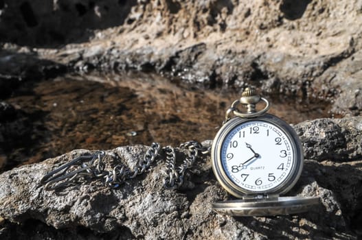 Time Concept Classic Vintage Pocket Clock on the Volcanic Rocks