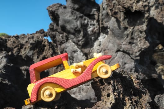 Transportation Concept Wooden Toy Car on the Rocks