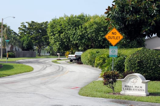 OAKLAND PARK, FLORIDA - JULY 1, 2013:  Royal Palm Lake Estates welcome sign at entrance to a nice and quiet suburban neighborhood with tropical foliage on a sunny day.