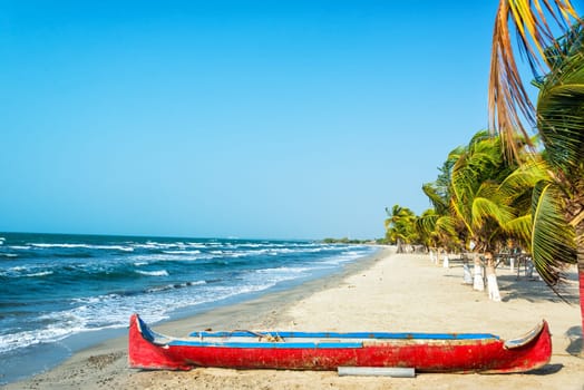 White sand Caribbean beach with a red canoe in the foreground