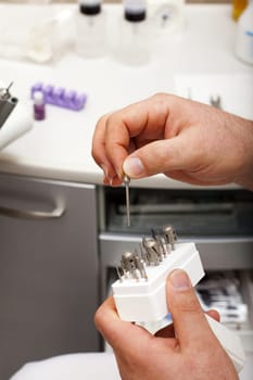 Foot care worker removes a sanding attachment