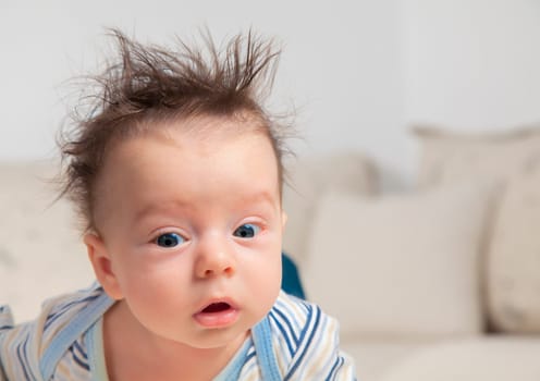 3 months old baby boy portrait with messy hair and sleepy.