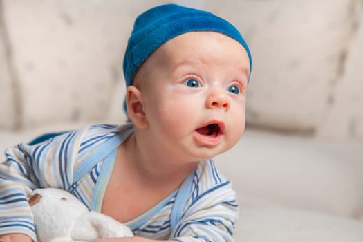 3 months old baby boy portrait at home trying to roll over.