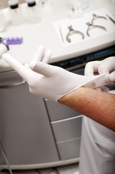 Foot care worker puts on gloves