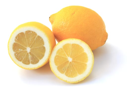 Lemons (Citrus x limon) ripe fruit,partly cut,exposed against a white background