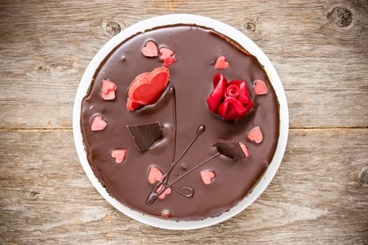 Chocolate cake decorated with sugar hearts and flower