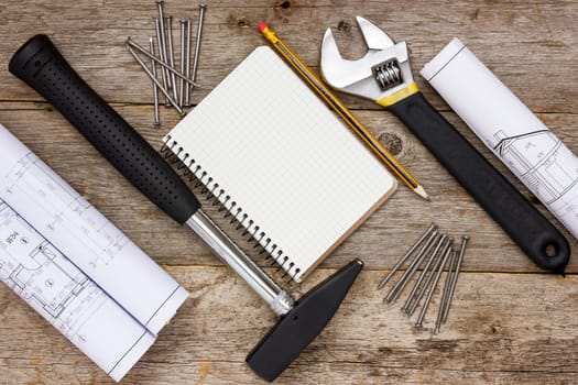 Tools , twisted technical drawing and blank notebook