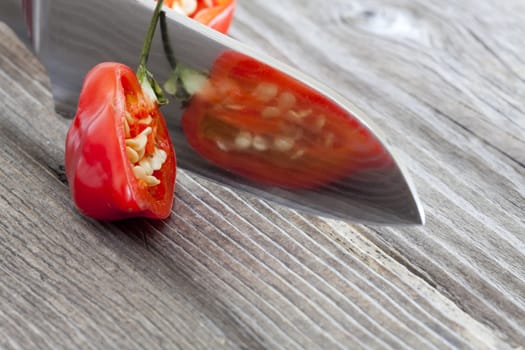 Halved Habanero chili pepper is reflected in the knife