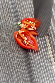 Halved Habanero chili pepper on wooden substrate