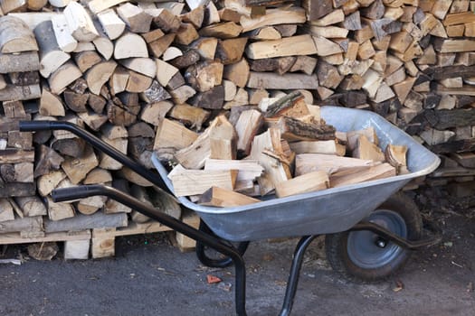 Stack of firewood and logs in the wheelbarrow