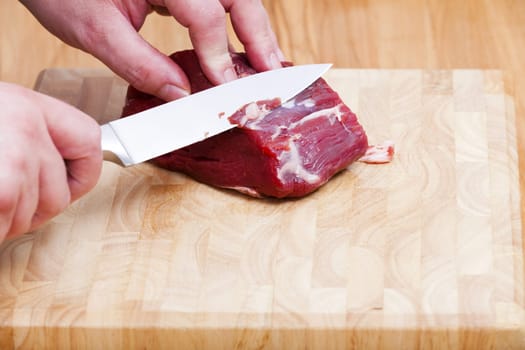 Remove fat residues from beef fillet with knife