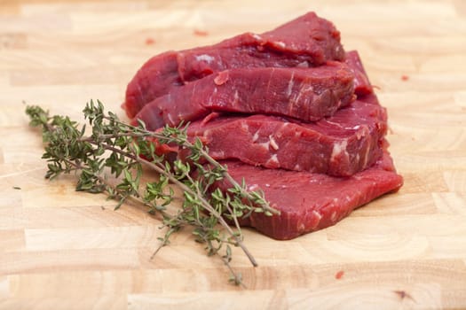 Four slices of beef fillet with thyme branch
