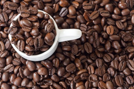 Espresso cup surrounded by many coffee beans