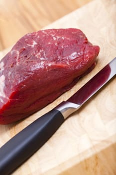 A piece of raw beef fillet on a cutting board
