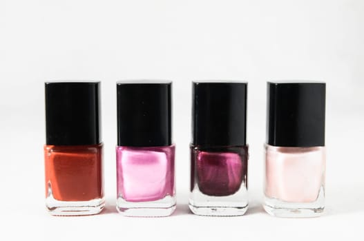 Colorful nail polish brush over white background
