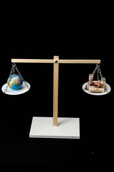 Globe Planet Earth and Money on a Two Pan Balance
