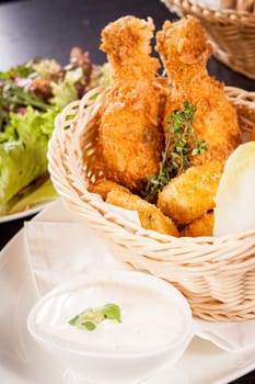 Crispy fried chicken wings with a dip on a plate