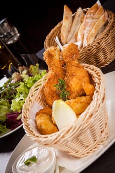 Crispy fried chicken wings with a dip on a plate
