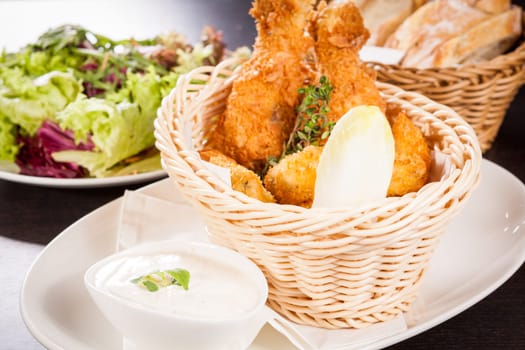 Crispy fried chicken wings with a dip on a plate