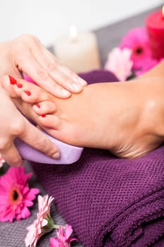 Woman with pedicure in a beauty salon on a towel with lactated toe nails