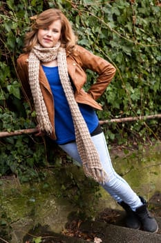 Pretty young woman teen on a road with vehicles outdoors in autumn