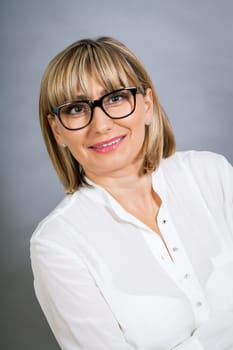 attractive adult woman in middle age with white blouse and brille
