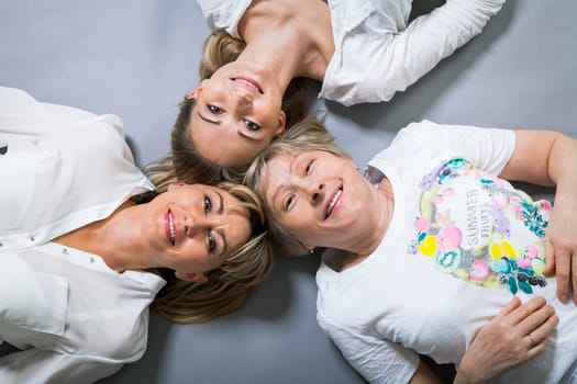 three generations grandmother mother and daughter in portrait against grey background family