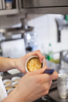 chef solves freshly baked tarts from the mould in the kitchen restaurant pastry shop