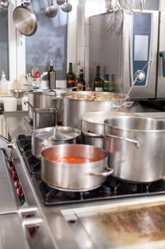 gastronomy restaurant kitchen with hob and steaming pots while cooking to prepare dinner dinner