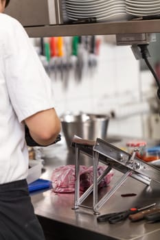 cook rubs fresh red beetroot on rub with gloves to protect against stains in the restaurant kitchen preparation eat